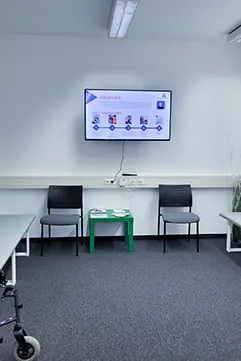 Besprechungsraum mit Bildschirm an der Wand und Stühlen