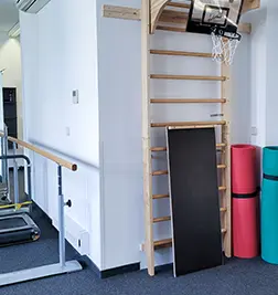 Sprossenwand mit Basketballkorb, daneben Therapierollen