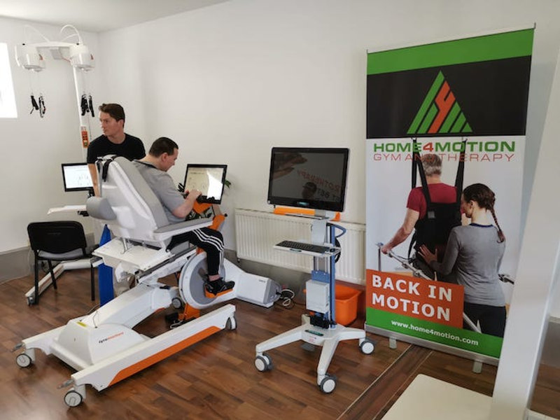 Physiotherapeut Martin Weißensteiner testet mit einem Betroffenen ein neues Therapiegerät für Gangtraining