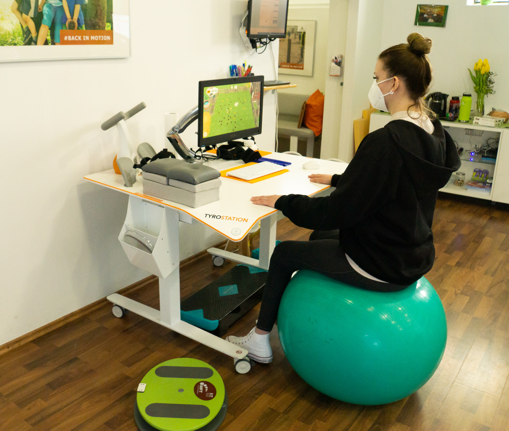 Patientin sitz am Ball und macht Übungen