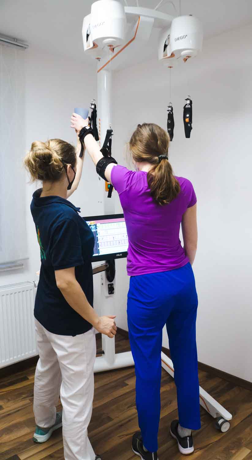 Patientin mit Therapeutin üben mit Handtrainer