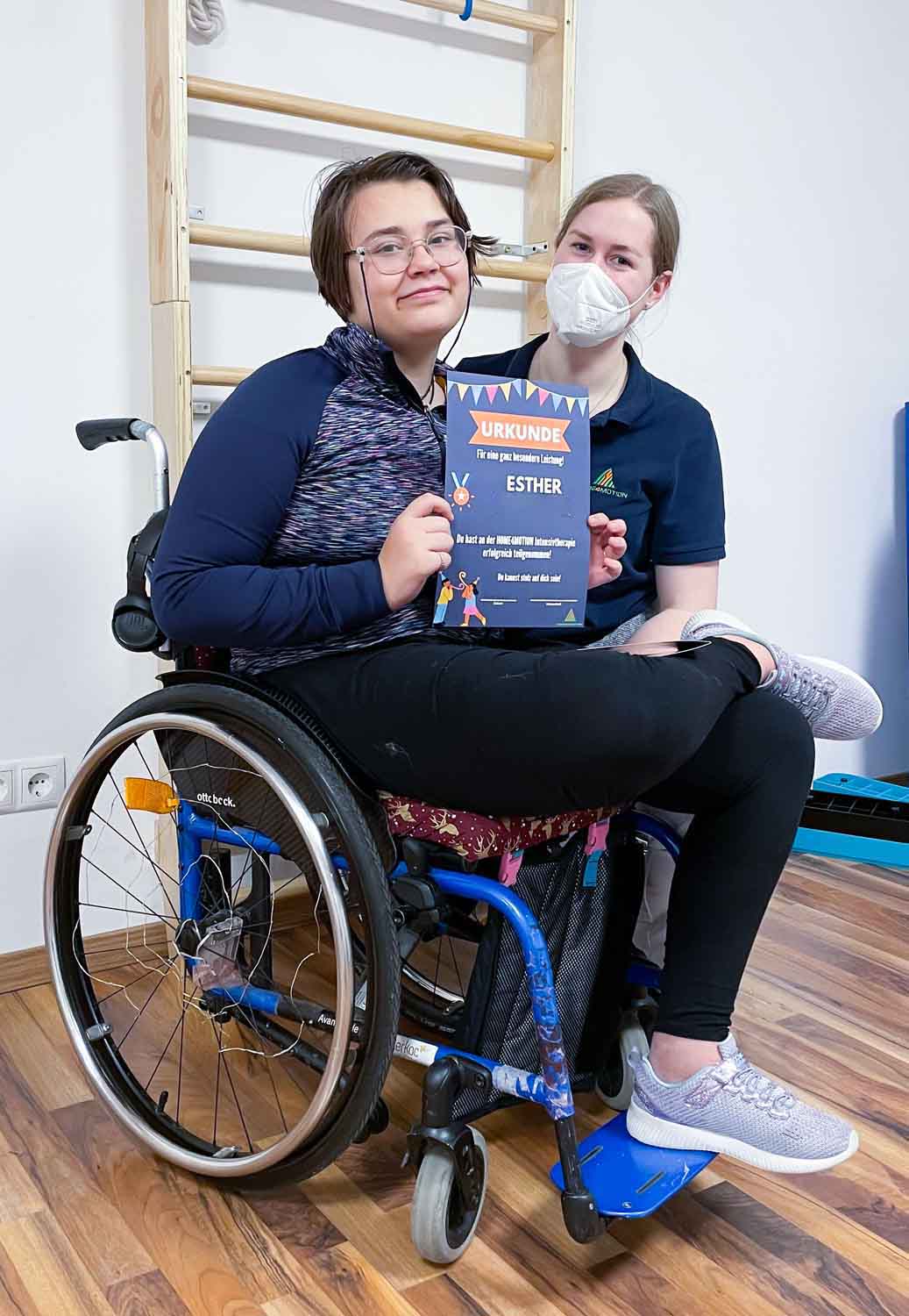 Kind im Rollstuhl mit Urkunde
