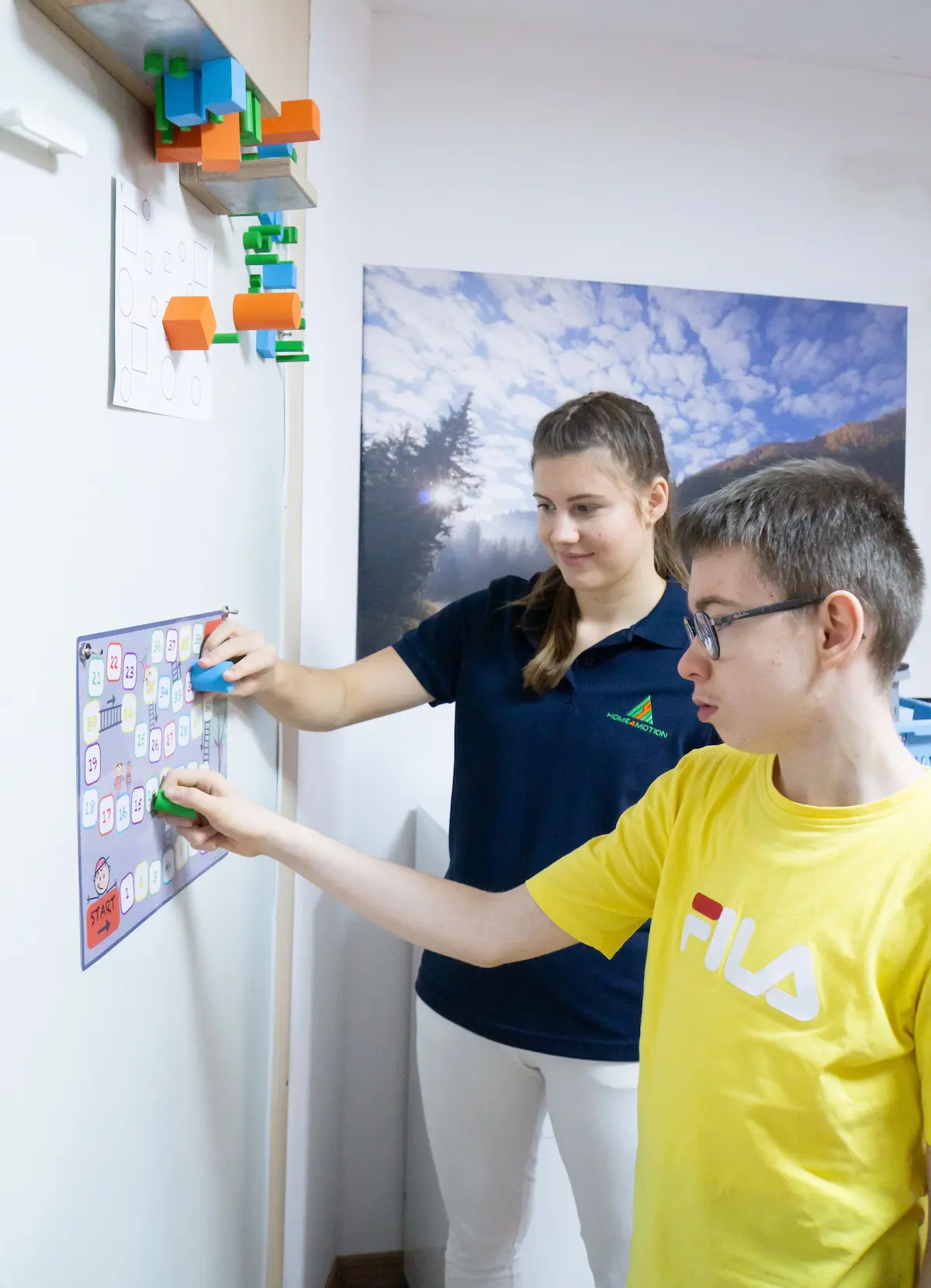 Kind mit Therapeutin spielen ein Spiel am Wand