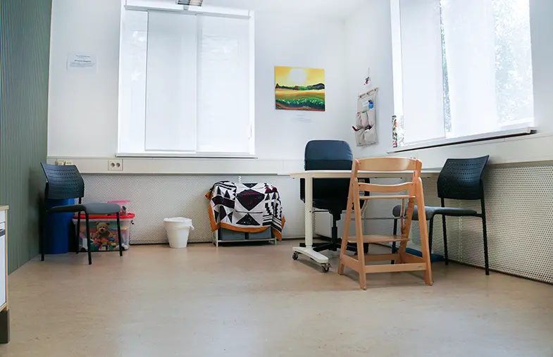 Beratungsraum mit Fensterfront, Tisch und Hochstuhl für kleine Kinder