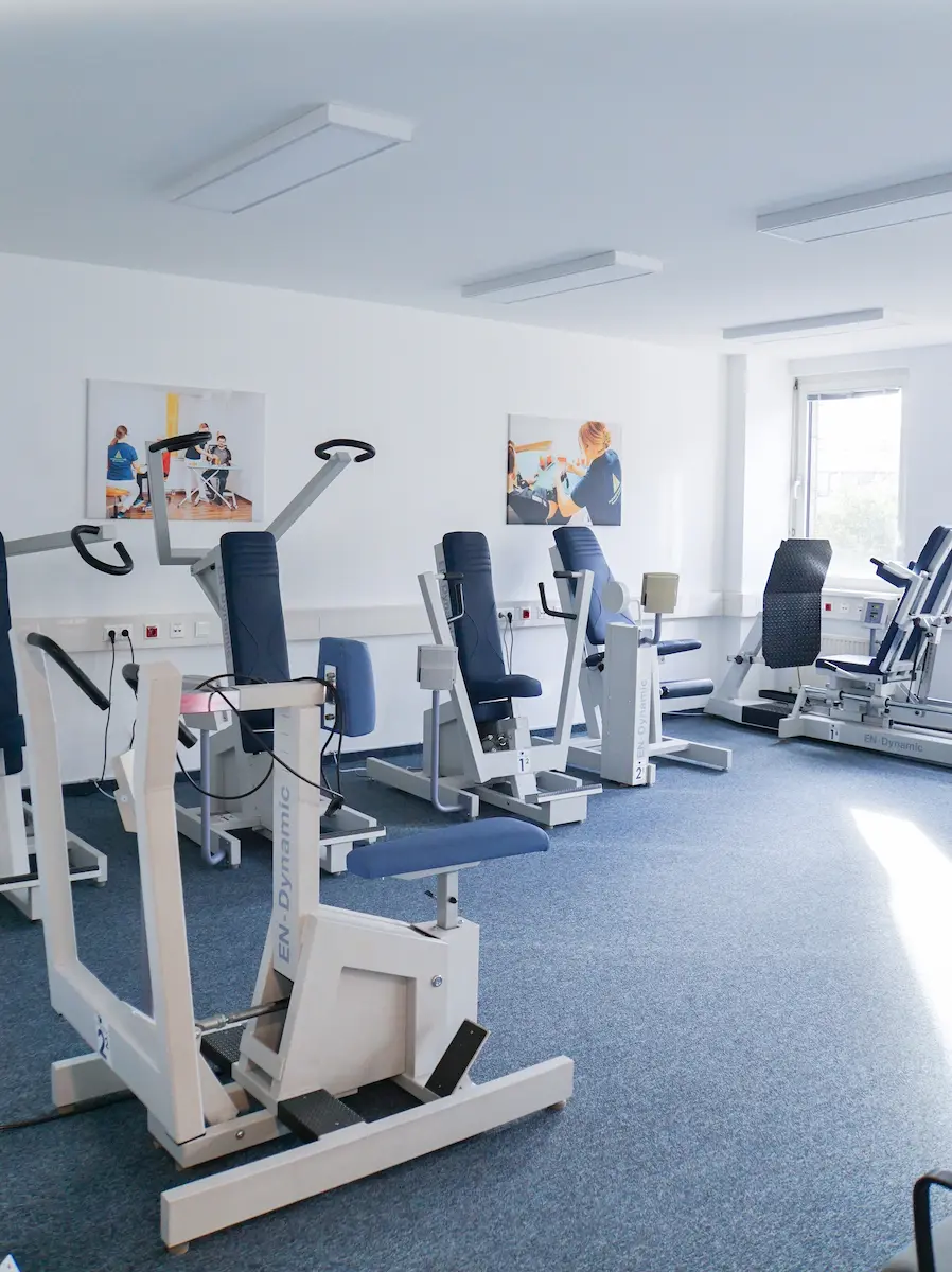 Trainingsraum mit mehreren Kraftgeräten an der Fensterseite
