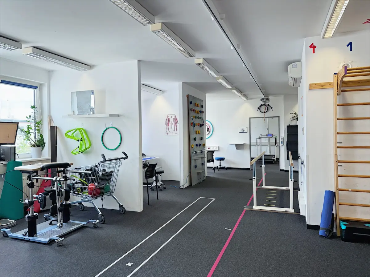 Langer Trainingsraum in Wien mit Gangtrainer, Gehbarren und Sprossenwänden