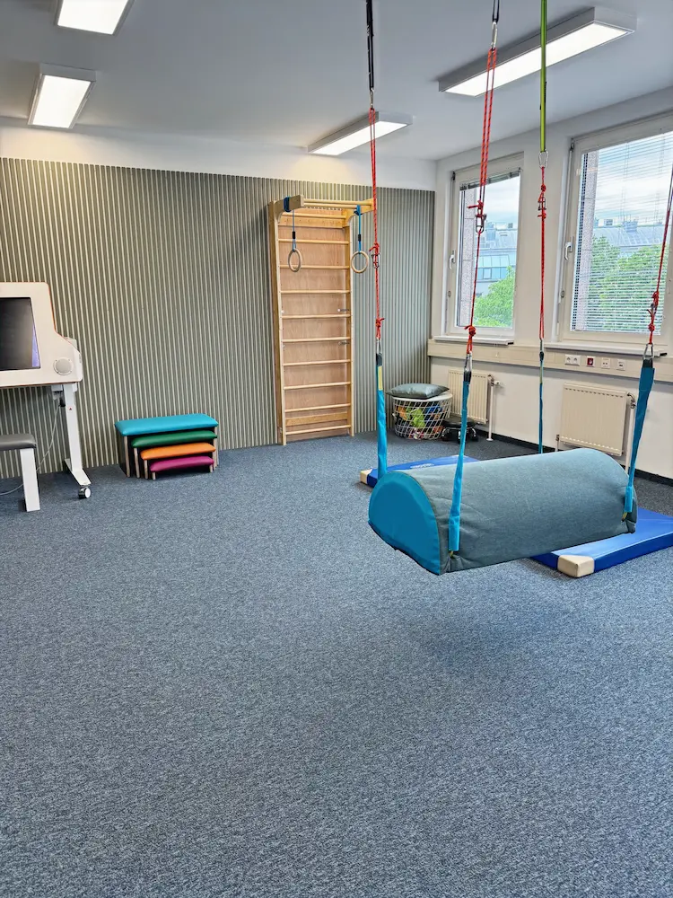 Therapieraum mit Sprossenwand, Hängematte und bunten Matten
